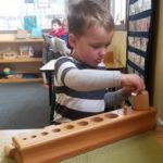 Ayden Sorting Peg Cylinders into their proper sized hole in wood block at school 2