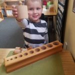 Ayden Sorting Peg Cylinders into their proper sized hole in wood block at school